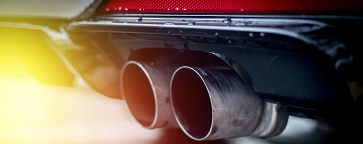 Powerful car with exhaust pipe, pollution and fine dust. Sunlight.  