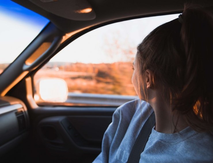 passeggera di un'auto in viaggio al tramonto