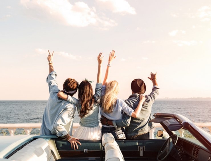 passeggeri di una cabriolet salutano