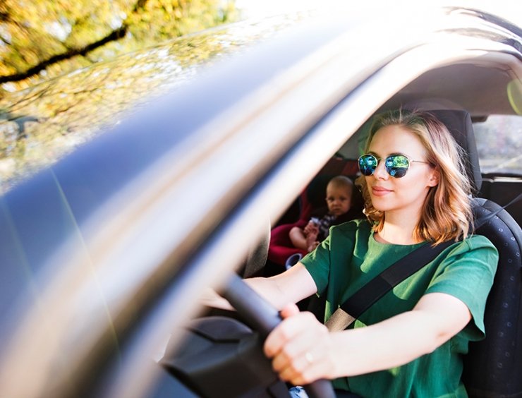 mamma alla guida con figlio seduto dietro nel seggiolino