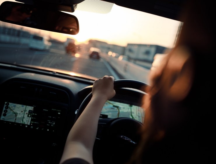 donna alla guida al tramonto